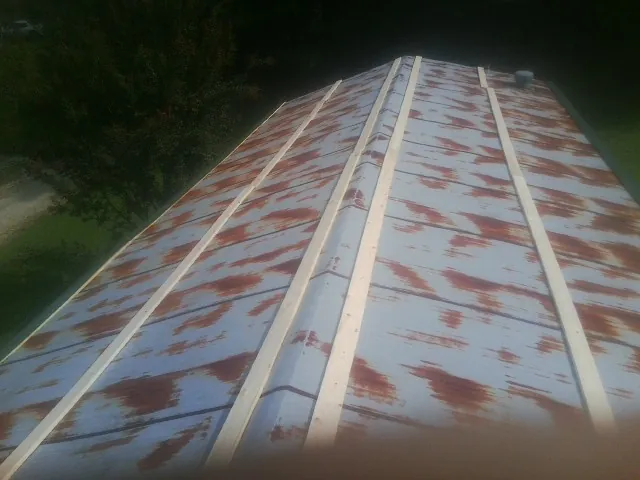 Rusted metal roof panels with new wood purlins before replacement — Storm Damage Roof Repair in Sodus by Roofing Brothers