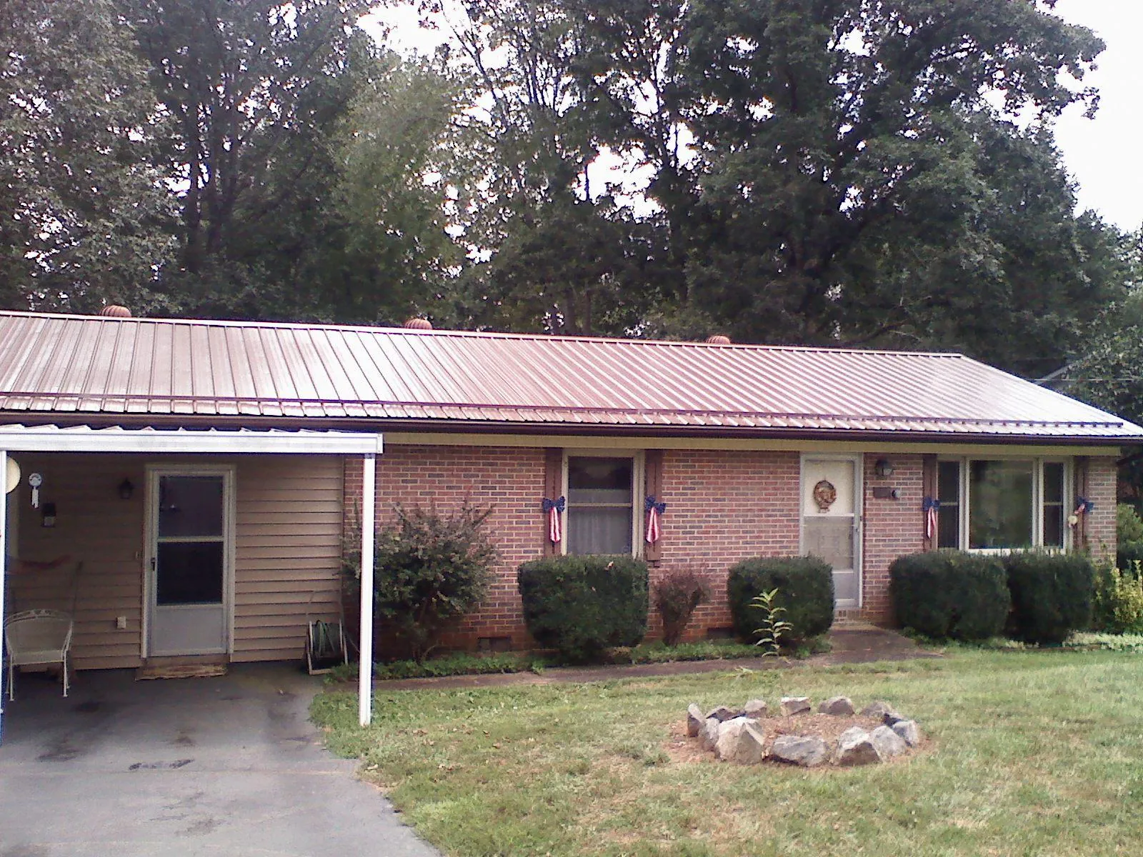 Bronze metal roof and carport on a brick ranch home — Roof Repair work by our crew in Sodus